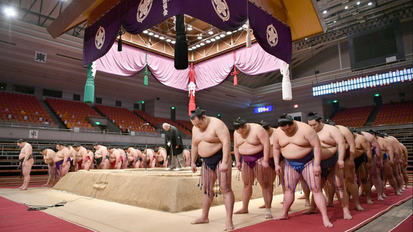 Các võ sĩ sumo cúi đầu chào trên sân khi kết thúc giải đấu được tổ chức nhưng không có khán giả vì dịch bệnh COVID-19 tại Osaka trong tháng 3 - Ảnh: NIKKEI