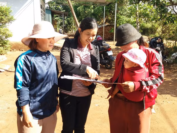 Cán bộ chi hội Phụ nữ làng Mơ Nú (xã Chư Á, TP. Pleiku) phát tờ rơi tuyên truyền việc khám sức khỏe tiền hôn nhân đến người dân. Ảnh: N.N