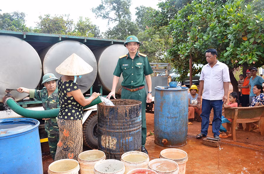 Lãnh đạo Công ty 72 huy động xe cơ quan chở nước cấp cho các hộ thiếu nước tại xã Ia Nan. Ảnh: T.T