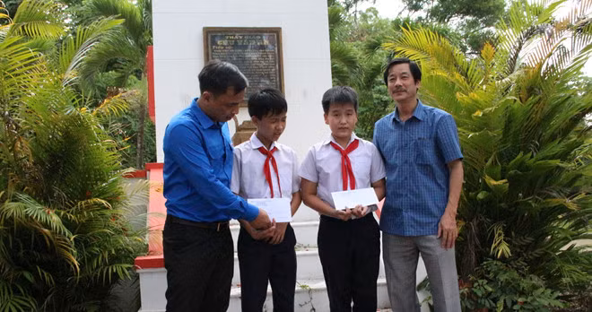 Anh Xiêng Thanh Phúc (bìa trái), Bí thư tỉnh đoàn Kon Tum, trao học bổng cho các em học sinh có hoàn cảnh khó khăn ẢNH: ĐỨC NHẬT