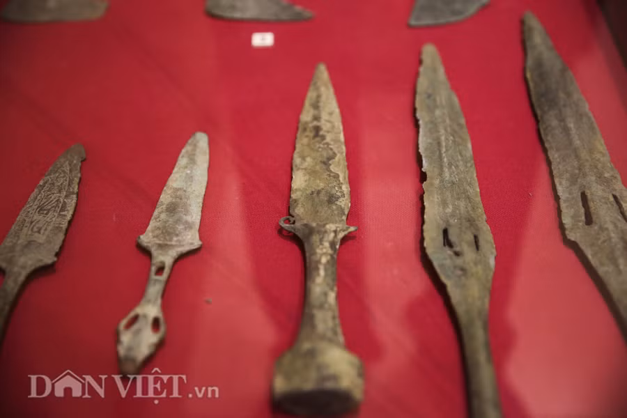 Trên ảnh là bộ sưu tập dao găm, niên đại thuộc văn hóa Đông Sơn muộn, cách ngày nay khoảng 1800 – 2300 năm. Dao găm của thời kỳ này không giống bất kỳ một loại vũ khí nào của các nền văn hóa khác. Nét độc đáo của dao găm Đông Sơn được thể hiện ở tất cả các bộ phận như; có hiện vật gắn chắn tay ngang, có loại là chắn tay quặp kiểu sừng trâu, lưỡi có loại gần hình tam giác, hai cạnh bên thẳng mũi nhọn. Cũng có loại hai cạnh bên cong vồng mũi tù, loại khác thì hai cạnh bên uốn lượn mũi nhọn.