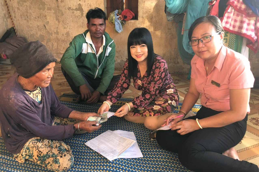 Giám đốc Bưu điện tỉnh và Giám đốc Bưu điện huyện Mang Yang trực tiếp đến tận nhà trao tiền cho đối tượng bệnh binh già yếu không đi lại được. Ảnh: Đinh Yến 