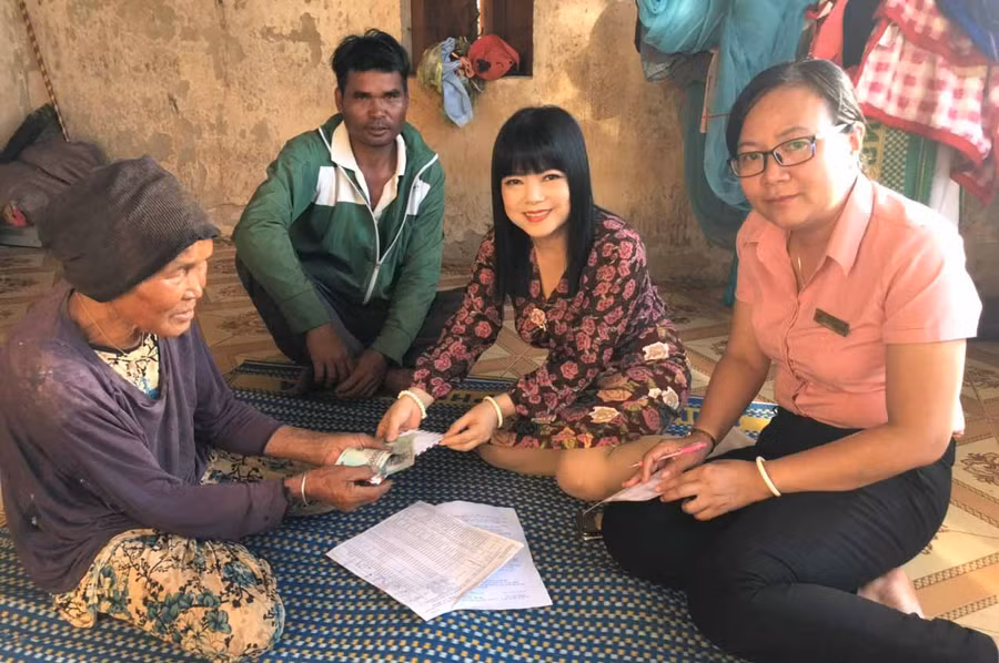 Giám đốc Bưu điện tỉnh và Giám đốc Bưu điện huyện Mang Yang trực tiếp đến tận nhà trao tiền cho đối tượng bệnh binh già yếu không đi lại được. Ảnh: Đinh Yến 