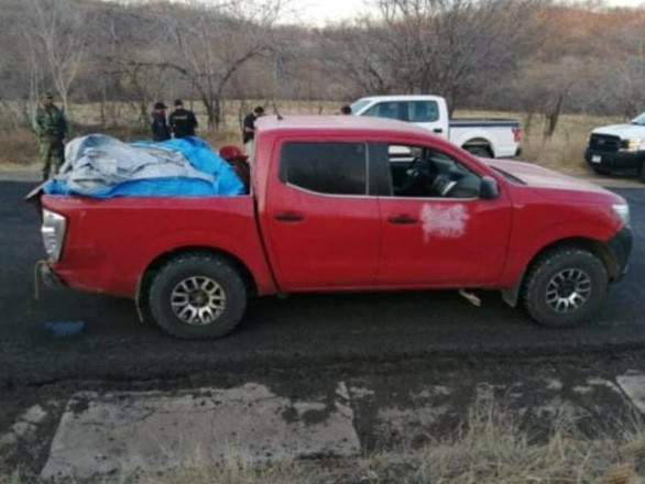  Chiếc xe bán tải với 12 thi thể bọc lại bằng vải bạt được để lại bên đường - Ảnh: BREIBART