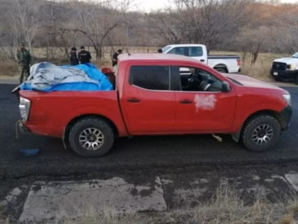  Chiếc xe bán tải với 12 thi thể bọc lại bằng vải bạt được để lại bên đường - Ảnh: BREIBART