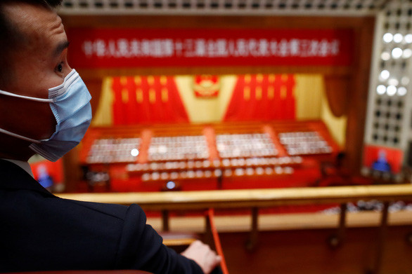 Một nhân viên an ninh đeo khẩu trang làm nhiệm vụ tại phiên họp ngày 25-5 của Quốc hội Trung Quốc tại Bắc Kinh - Ảnh: REUTERS