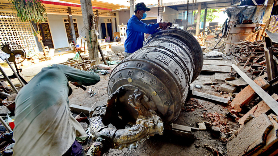 Các nghệ nhân làng nghề Phường Đúc xứ Huế nổi tiếng với kĩ thuật đúc chuông đồng có âm hay, dáng đẹp. Ảnh: Thái Hoàng