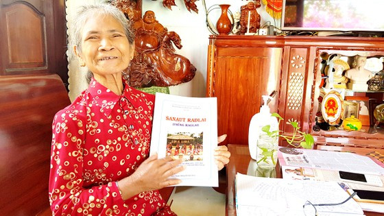 Bà Mẫu Thị Bích Phanh vui khoe cuốn sách chữ Raglai đầu tiên được xuất bản có sự góp công của bà