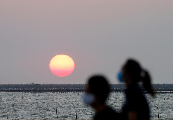 Người dân đeo khẩu trang khi ra ngoài ở tỉnh Chon Buri, phía đông Bangkok, Thái Lan - Ảnh: REUTERS