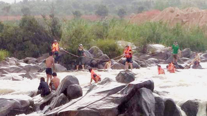 Lực lượng cứu hộ tìm kiếm nạn nhân bị nước lũ cuốn trôi tại thác Liêng Ệp. ẢNH: TRÙNG DƯƠNG