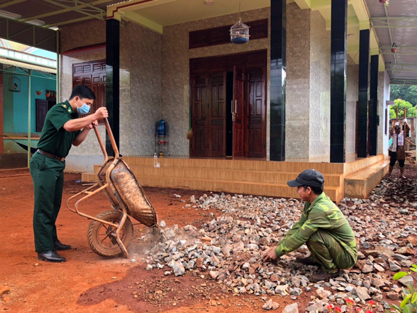Trung úy Hoàng Văn Thủy giúp gia đình anh Rơ Lan Tian (làng Nú, xã Ia Nan, huyện Đức Cơ) làm sân bê tông. Ảnh: A.H