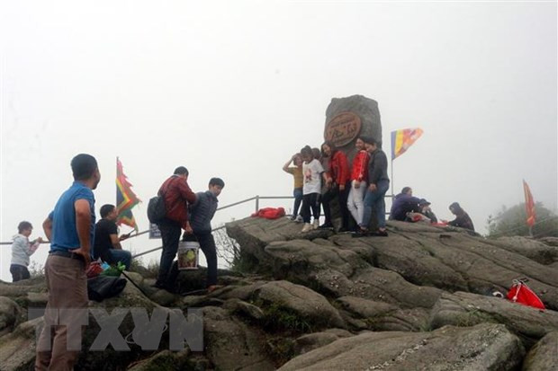 Du khách chụp ảnh lưu niệm trên đỉnh thiêng Yên Tử. (Ảnh: Đức Hiếu/TTXVN)