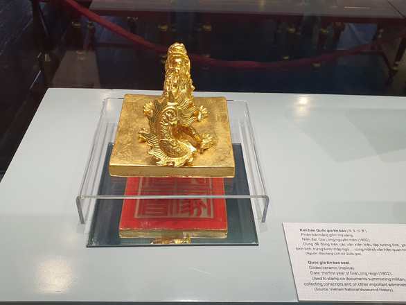 Kim bào Quốc gia tín báo thời Triều Nguyễn được phát họa lại phiên bản bằng gốm mạ vàng được trưng bày - Ảnh: PHƯỚC TUẦN