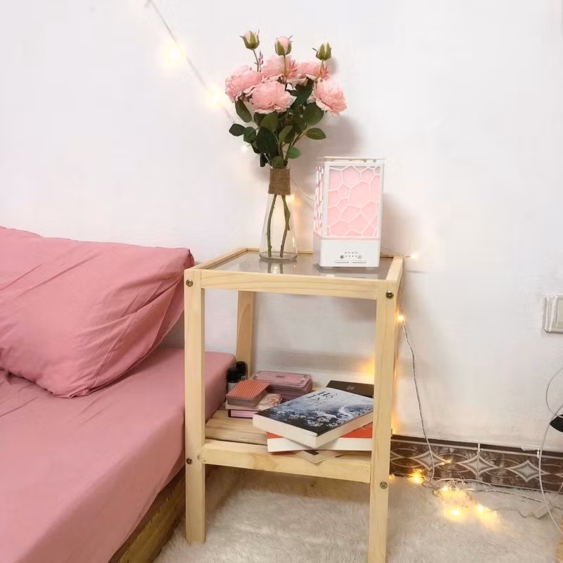 Tap đầu giường để đèn ngủ kèm xông tinh dầu, bên dưới để sách.