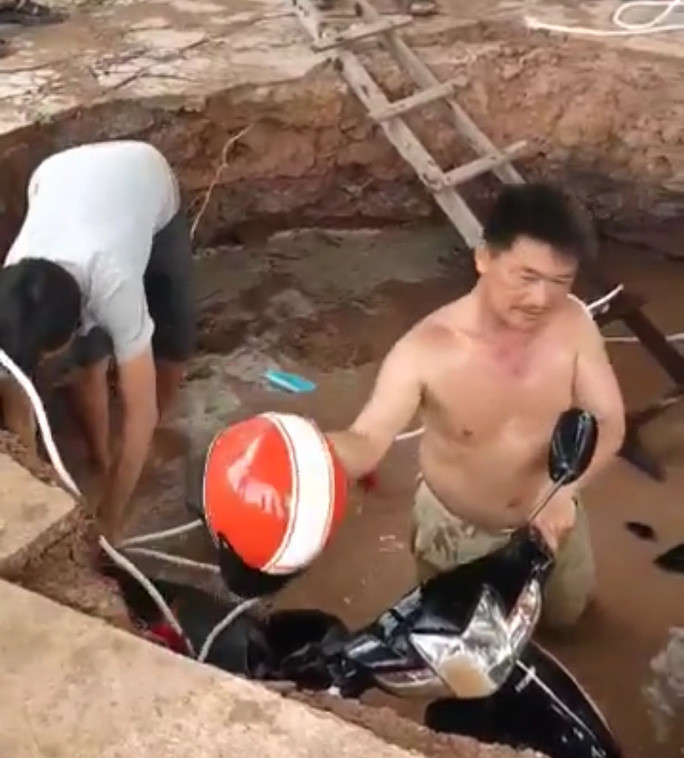 Người dân phụ giúp đưa xe máy lên