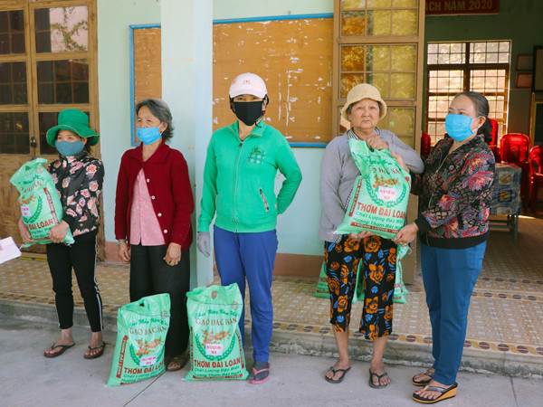 Bà Nguyễn Thị Tín-chủ nhà xe Phước Hưng (bìa phải) hỗ trợ 1,6 tấn gạo cho người nghèo bị ảnh hưởng bởi dịch Covid-19 trên địa bàn thị xã An Khê. Ảnh: N.M