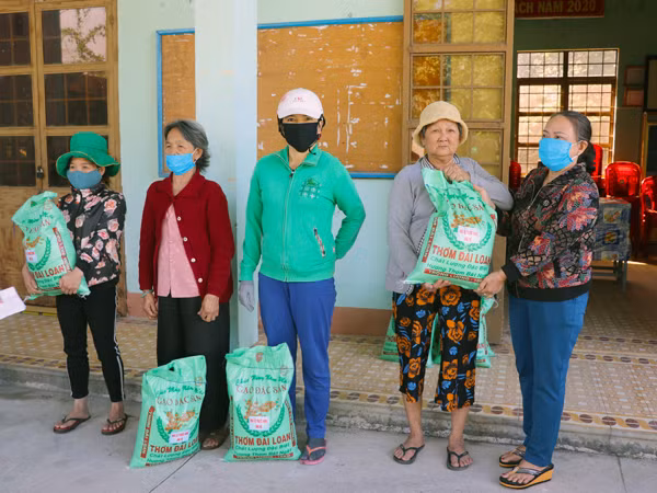 Bà Nguyễn Thị Tín-chủ nhà xe Phước Hưng (bìa phải) hỗ trợ 1,6 tấn gạo cho người nghèo bị ảnh hưởng bởi dịch Covid-19 trên địa bàn thị xã An Khê. Ảnh: N.M