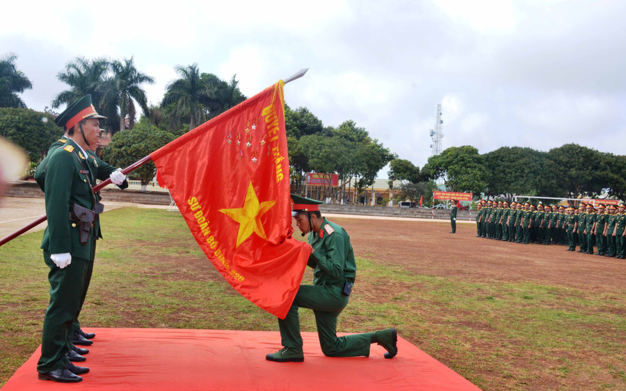 Chiến sĩ mới đọc lời thề và hôn Quân kỳ thể hiện quyết tâm bảo vệ Tổ quốc. Ảnh: Phương Dung