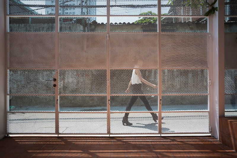 Cổng làm bằng hoa sắt có thể dễ dàng quan sát người bên ngoài.