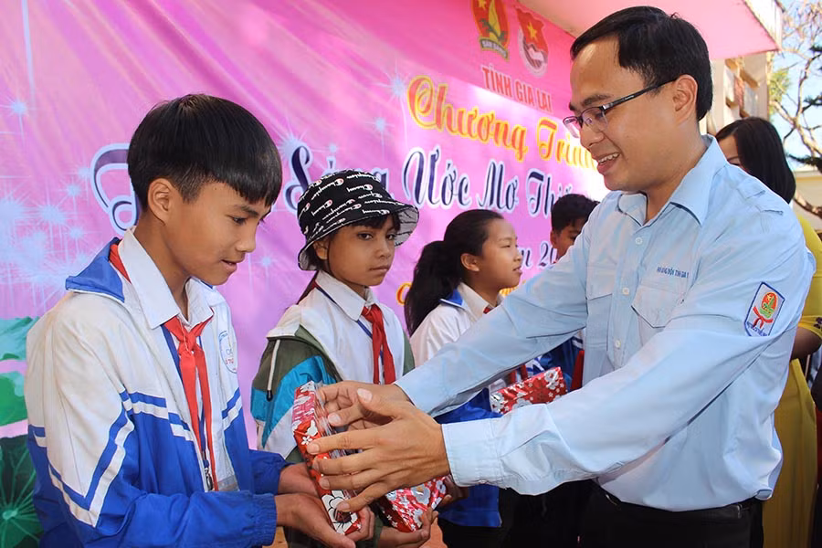 Anh Đỗ Đức Thanh-Phó Chủ tịch Hội đồng Đội tỉnh tặng quà các em học sinh khó khăn tại chương trình “Thắp sáng ước mơ thiếu nhi Gia Lai” tổ chức vào cuối năm 2019. Ảnh: P.L