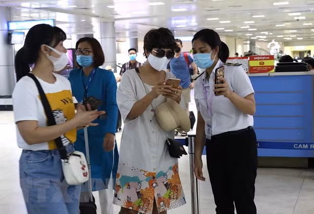 Nhân viên mặt đất kiểm tra mã khai báo y tế hành khách tại sân bay. (Ảnh: Ngọc Hà/TTXVN)