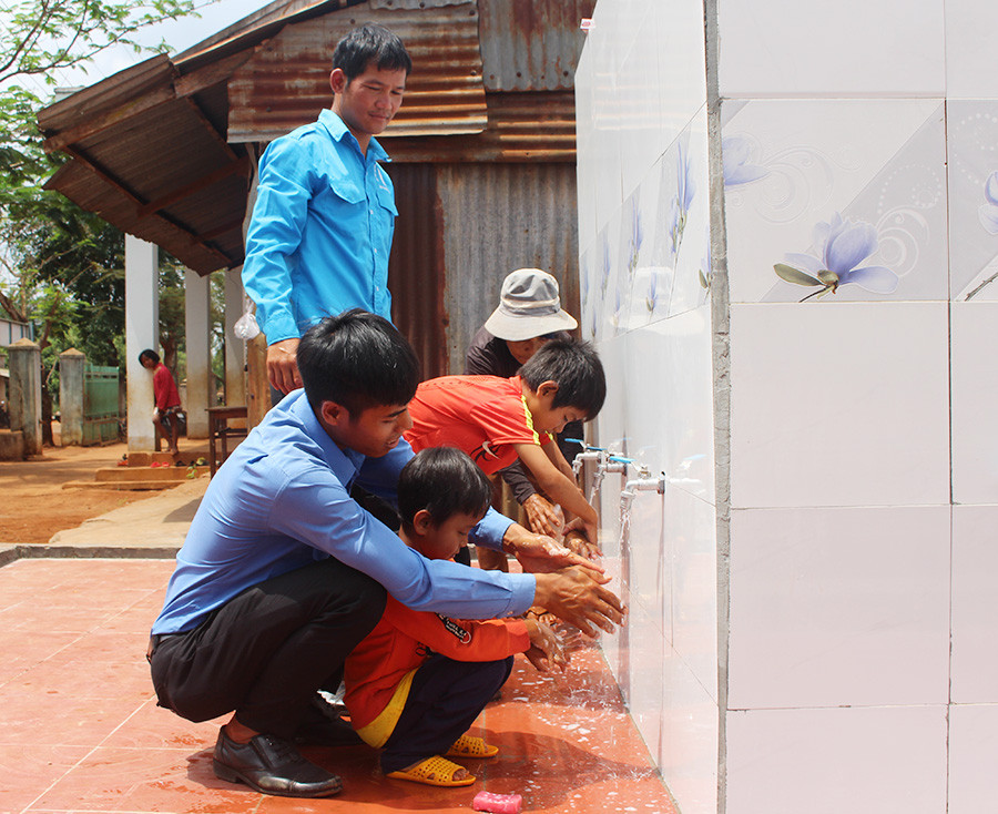  Người dân và các em nhỏ làng Alphun (xã Ia Pết, huyện Đak Đoa) sử dụng nước sạch từ công trình do ĐVTN thực hiện. Ảnh: P.L