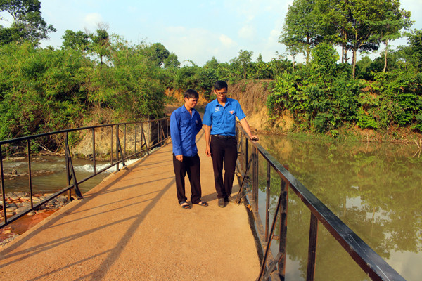  Anh Hoàng Văn Thành (bìa phải) kiểm tra lan can đập tràn (phần việc thanh niên) ở làng Mrông Ngó 4. Ảnh: T.B