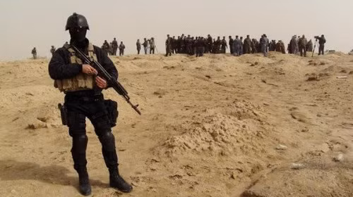 Các quan chức và nhân viên cảnh sát tập trung tại hố chôn tập thể