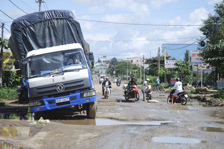 Cảnh tài xế và người dân khổ sở vượt qua đoạn đường đầy “ổ voi”, hố sâu tại khu vực ngã ba Vạn Kiếp-Lê Đại Hành. Ảnh: Nguyễn Giác 