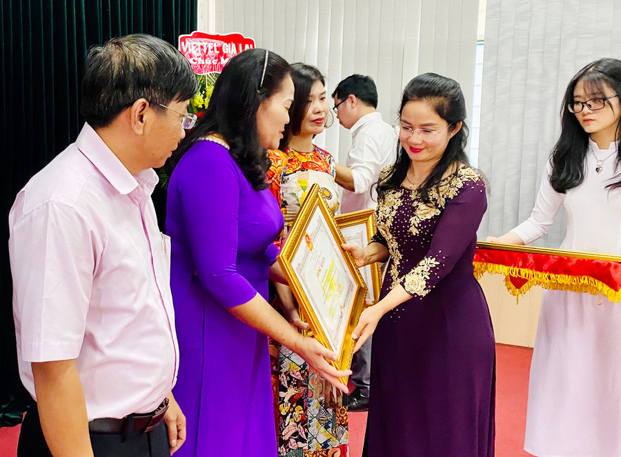 Bà Bùi Khoa Nghi-Phó Giám đốc Sở GD-ĐT trao tặng bằng khen của Chủ tịch UBND tỉnh cho các cá nhân có thành tích xuất sắc trong phong trào thi đua “Huy động và duy trì sĩ số học sinh”. Ảnh: Mộc Trà