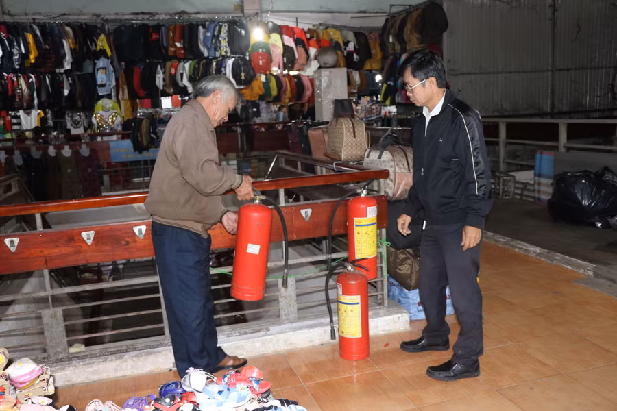 Thành viên Ban quản lý chợ An Khê kiểm tra bình cứu hỏa tại khu vực buôn bán giày dép, quần áo. Ảnh: Ngọc Minh