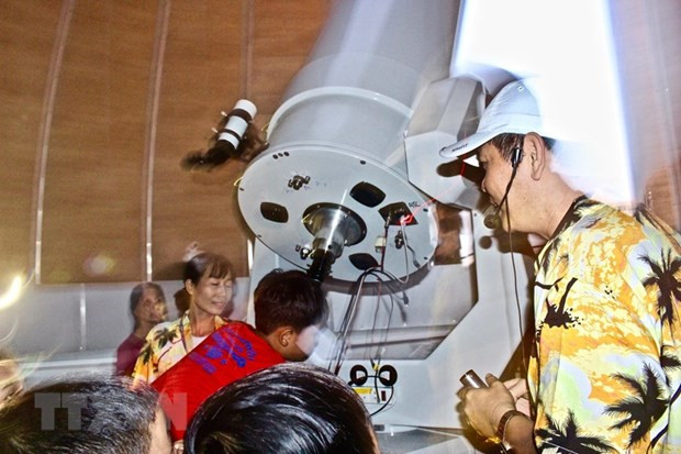 Các bạn nhỏ được trực tiếp ngắm Mặt Trăng thông qua kính thiên văn của Đài thiên văn Nha Trang. (Ảnh: Phan Sáu/TTXVN)