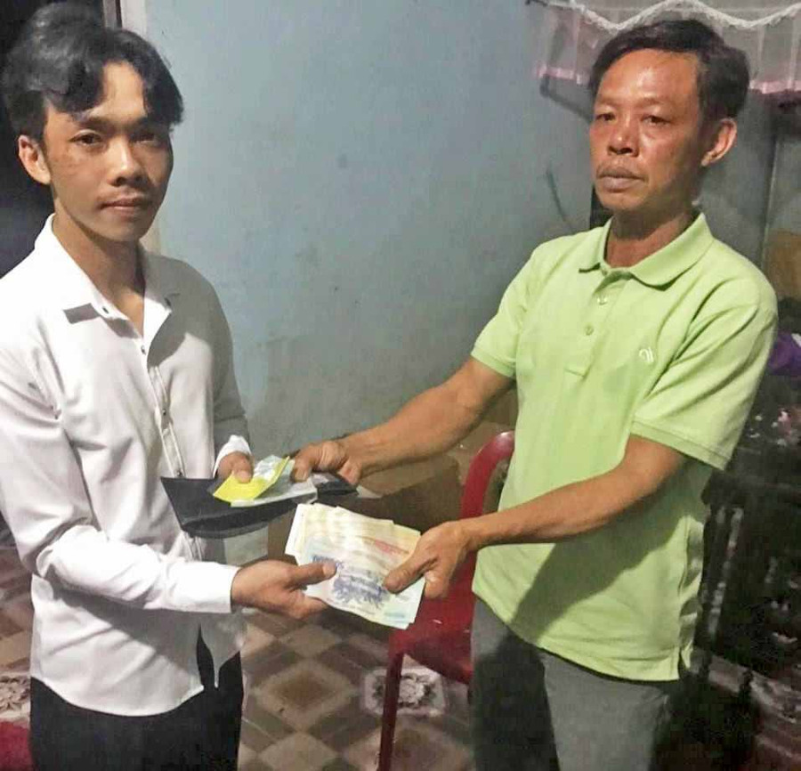 Anh Lê Văn Oai (bìa phải) trao trả toàn bộ giấy tờ và số tiền 27.766.000 đồng cho anh Nguyễn Minh Hoàng. Ảnh: Thúy Trinh