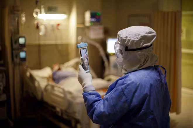 Nhân viên y tế trò chuyện với người gia đình qua điện thoại trong đêm giao thừa 31.12.2020 tại bệnh viện ở thành phố Ciudad Juarez, Mexico - Ảnh: Reuters Nhân viên y tế trò chuyện với người gia đình qua điện thoại trong đêm giao thừa 31.12.2020 tại bệnh viện ở thành phố Ciudad Juarez, Mexico - Ảnh: Reuters