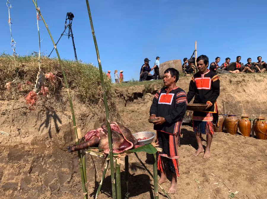 Thầy cúng Kpă Thơi cùng phụ tá thực hiện nghi lễ cúng bến nước. Ảnh: Vũ Chi