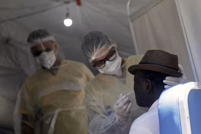 Nhân viên y tế đang lấy mẫu xét nghiệm của bệnh nhân. Ảnh: Reuters
