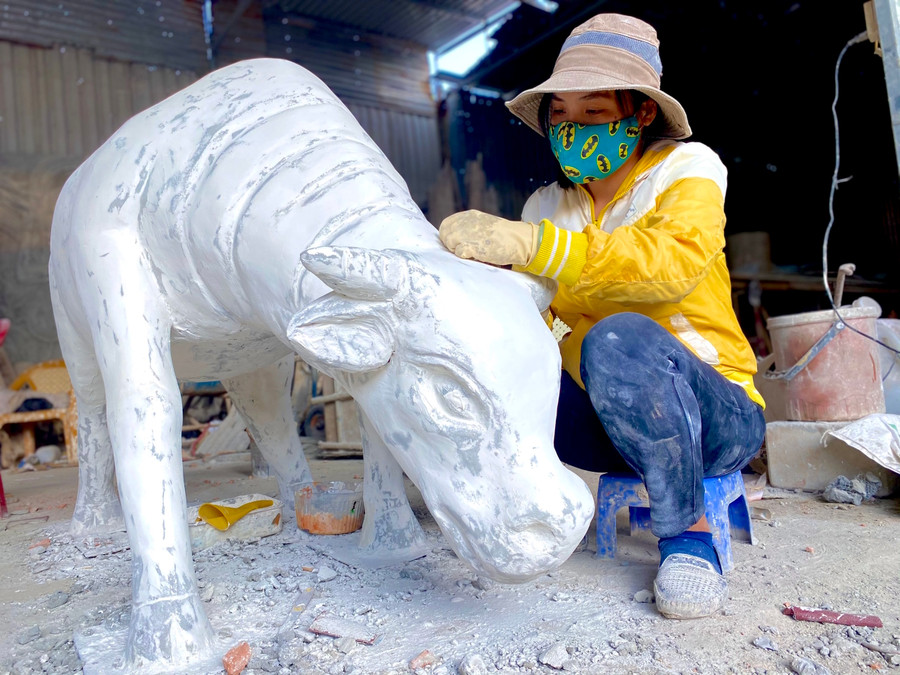 - Ảnh 2: Chị Lê Thị Ngọc-chủ cơ sở điêu khắc Nguyễn Vinh-cho biết, bên cạnh sản xuất tượng, phù điêu, non bộ, vẽ tranh trang trí... mỗi dịp Tết đến Xuân về, cơ sở còn nhận thêm các hợp đồng làm linh vật của năm bằng xi măng, thạch cao hoặc nhựa tổng hợp compusite.