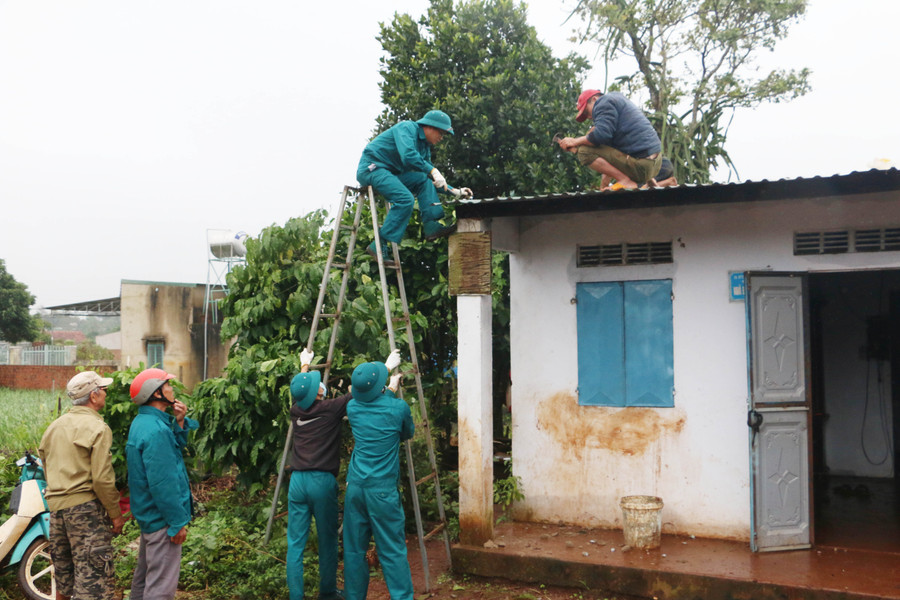 Lực lượng dân quân xã Biển Hồ (TP. Pleiku) hỗ trợ người dân lợp lại mái nhà bị tốc do bão số 9 gây ra. Ảnh: Quang Tấn
