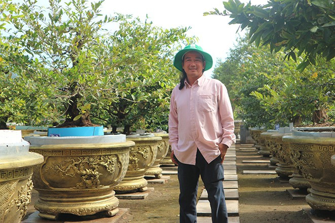 Anh Nguyễn Hoàng Tuấn bên những chậu mai độc đáo, có giá trị cao. ẢNH: THIÊN LỘC