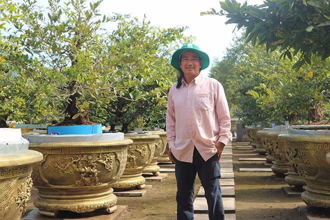 Anh Nguyễn Hoàng Tuấn bên những chậu mai độc đáo, có giá trị cao. ẢNH: THIÊN LỘC