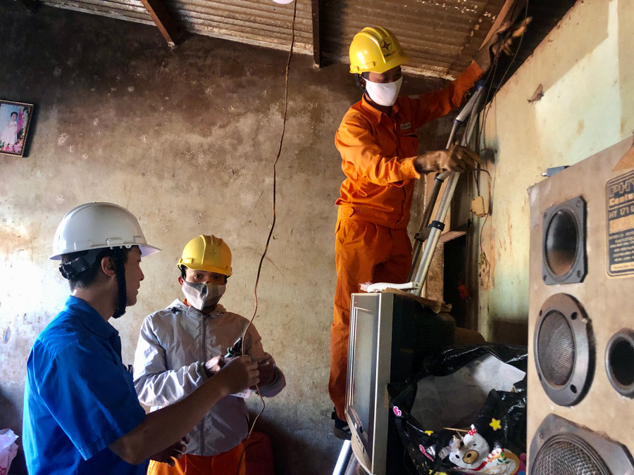Công nhân Công ty Điện lực Gia Lai sửa chữa hệ thống điện miễn phí cho các hộ nghèo tại xã An Phú, TP. Pleiku. Ảnh: Ngọc Thu