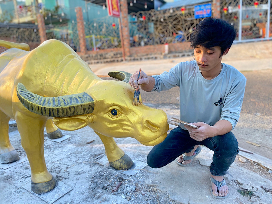 - Ảnh 9: Công đoạn sơn vẽ trang trí cũng không kém phần quan trọng để “thổi hồn” vào linh vật. Tùy theo yêu cầu của khách mà cơ sở tạo hình và màu sắc giống trâu thật hoặc cách điệu thành trâu vàng, trâu hoạt hình. 