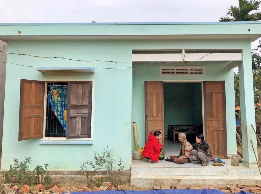 Ông Đinh Gol (ngồi giữa) bên ngôi nhà mới vừa được hỗ trợ xây dựng mới từ quỹ đền ơn đáp nghĩa