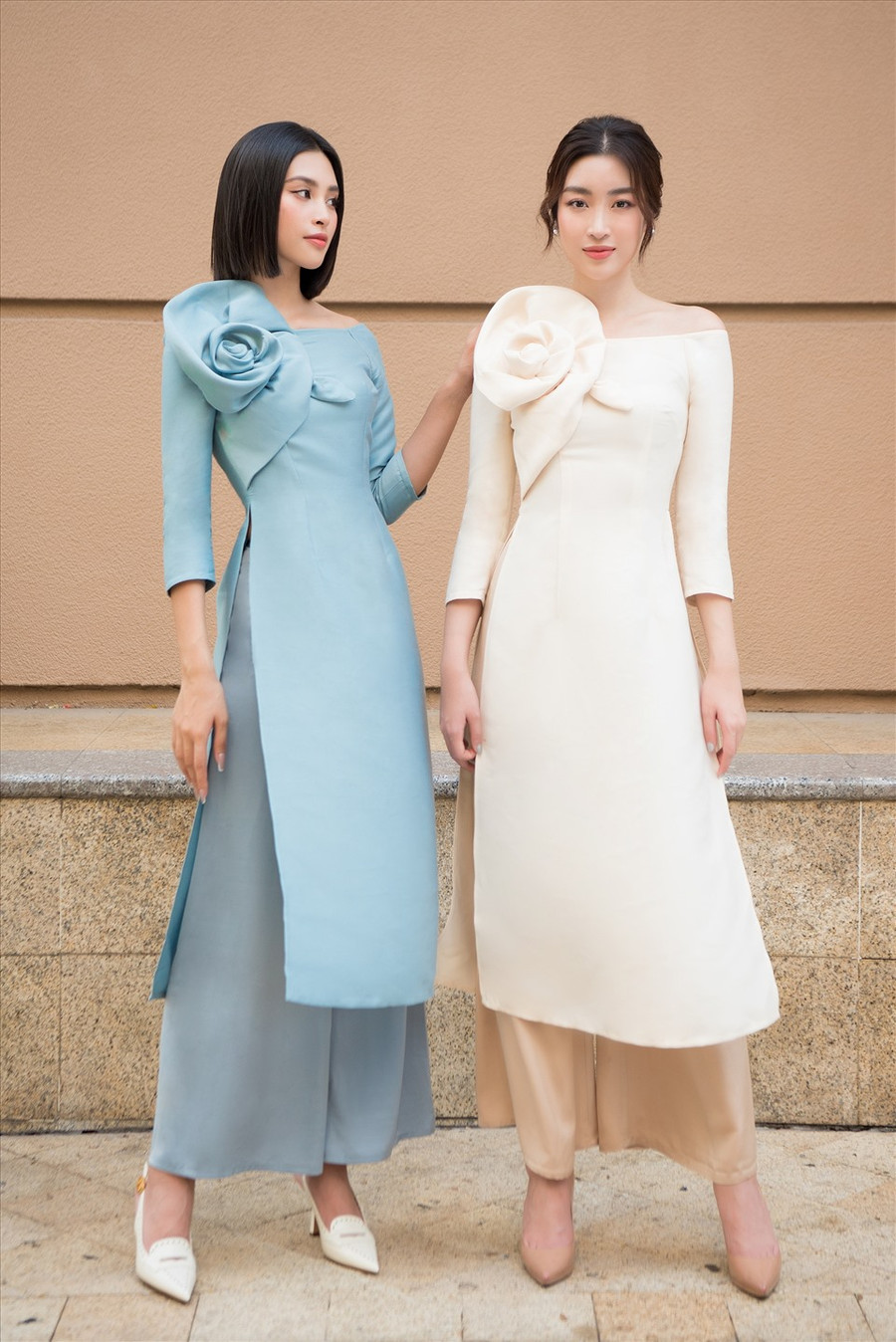 Dịp tết đến, xuân về, tà áo dài luôn là lựa chọn hàng đầu của phái đẹp. Là những hoa hậu hiện đại, Đỗ Mỹ Linh và Tiểu Vy lựa chọn cho mình những chiếc áo dài cách tân, vạt ngắn với điểm nhấn xếp phồng ở vai tôn lên sự nữ tính, sang trọng. Ảnh: Quang Đức.