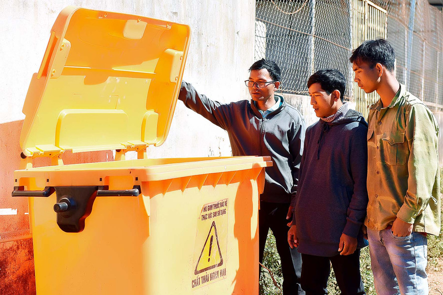 7.Đảng viên Rơ Lan Mur tuyên truyền người dân sử dụng thùng chứa rác thải nguy hại sau khi sử dụng để bảo vệ môi trường.