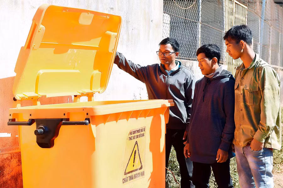 7.Đảng viên Rơ Lan Mur tuyên truyền người dân sử dụng thùng chứa rác thải nguy hại sau khi sử dụng để bảo vệ môi trường.