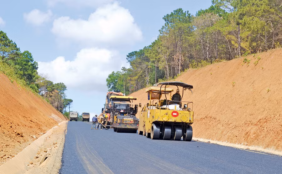  Đơn vị thi công tiến hành thảm bê tông nhựa đường Hồ Chí Minh-đoạn tuyến tránh đô thị Pleiku. Ảnh: Lê Hòa