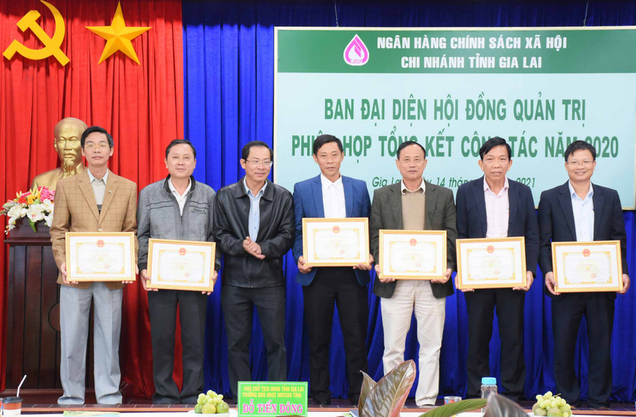 Phó Chủ tịch Thường trực UBND tỉnh, Trưởng Ban đại diện Hội đồng Quản trị Ngân hàng CSXH tỉnh Đỗ Tiến Đông tặng giấy khen cho các tập thể có thành tích trong công tác phối hợp