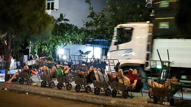 Lao động bốc xếp ngủ trên các xe kéo hàng. Ảnh: PHẠM THU NGÂN