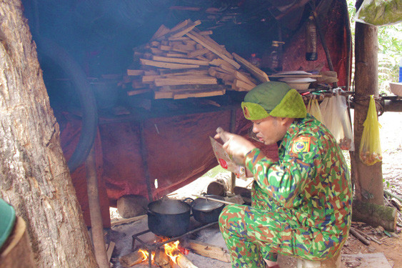 Trung úy Hồ Sỹ Đông, Đồn Biên phòng cửa khẩu quốc tế Cha Lo, chuẩn bị bữa cơm chiều cho đồng đội tại chốt bản Cha Lo. Ảnh: HOÀNG PHÚC